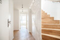 Heller Flur mit Holztreppe