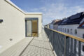 Helle Terrasse mit Blick auf Gebäude.