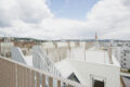 Dachterrasse mit Stadtblick und Wolken.