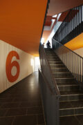 Treppenhaus mit orangefarbener Wandgestaltung.