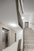 Heller Flur mit Treppe und Aufzug.