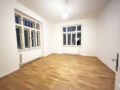 Helle, leere Wohnung mit Holzfußboden.